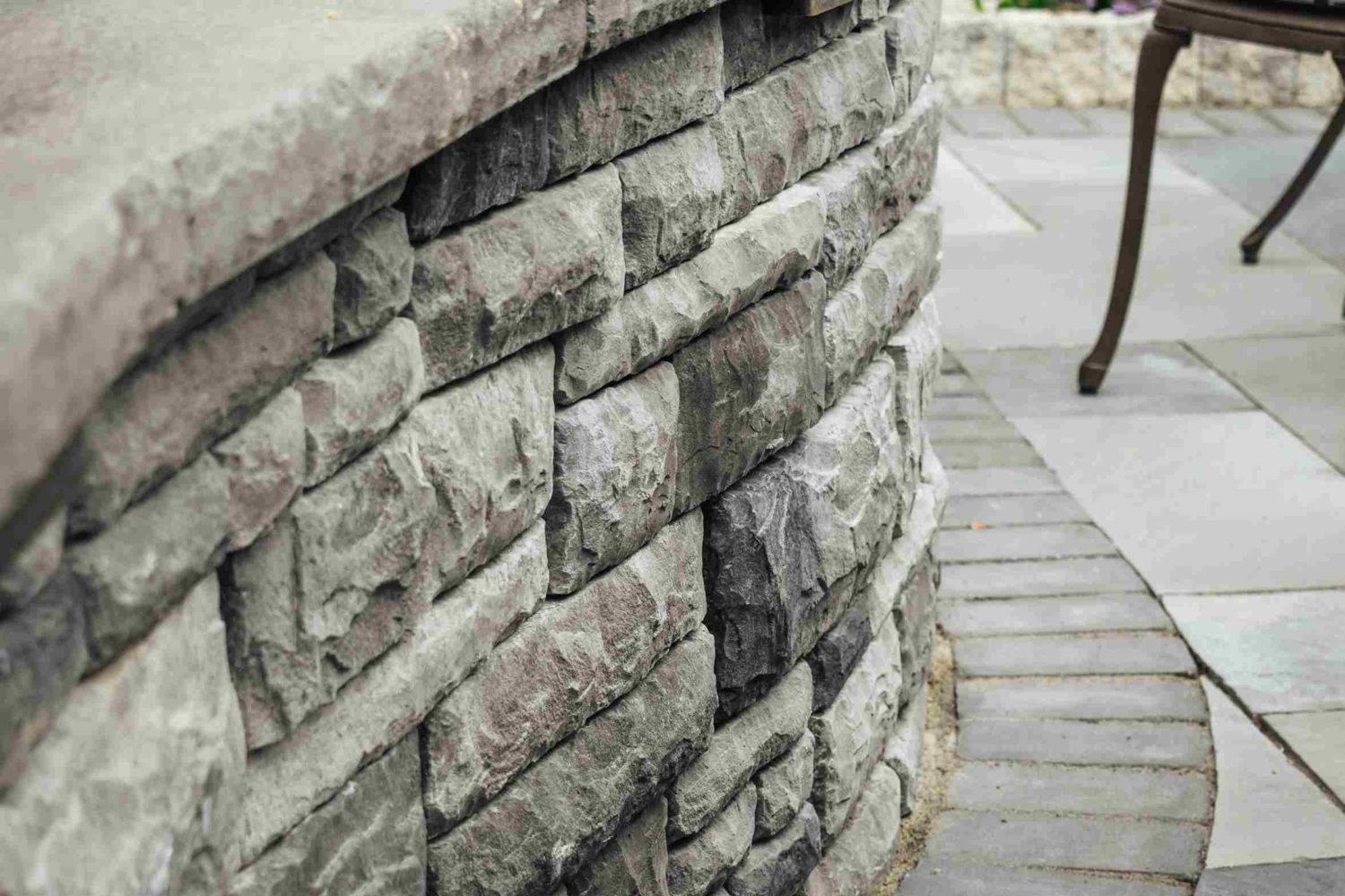 Curved stone wall detail — hardscaping enhanced by strategic landscape lighting