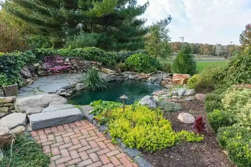 Koi pond with waterfall and accent lighting in a Chester County backyard