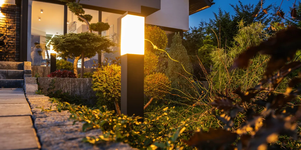 Low-voltage landscape lighting illuminating a garden path at dusk on a Chester County PA property - outdoor living upgrades by Pickel Landscape Group