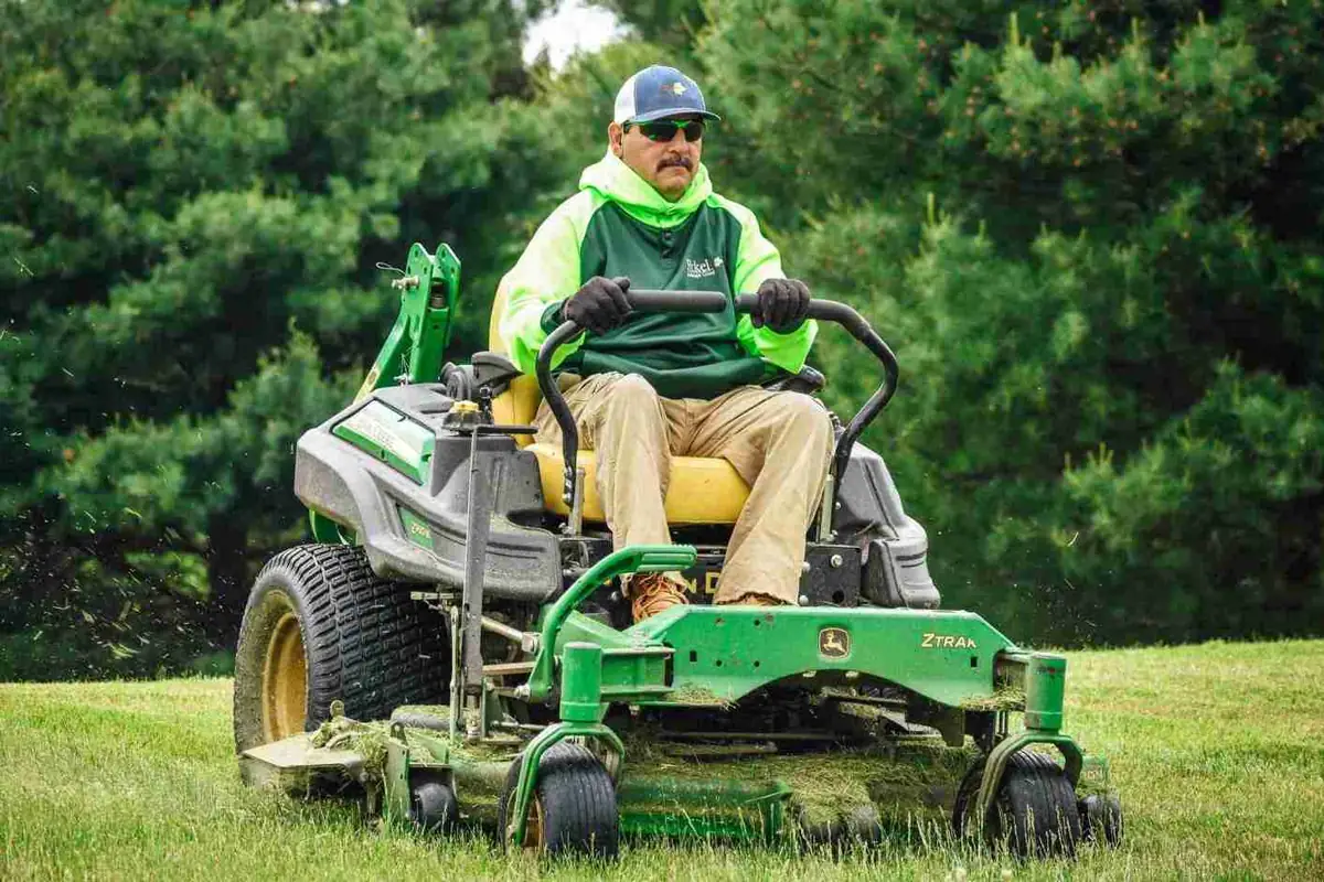 Crew member on zero-turn mower